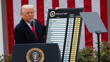 Trump mit einer Tafel, auf der die Höhe der Zölle für einzelne Länder stehen.