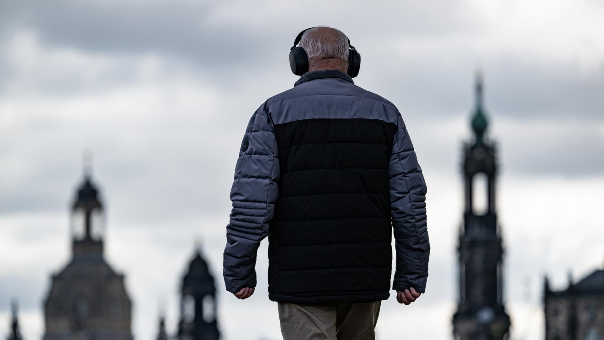 Ein Mann ist auf dem Elberadweg in Dresden unterwegs und trägt dabei Kopfhörer. | picture alliance/dpa