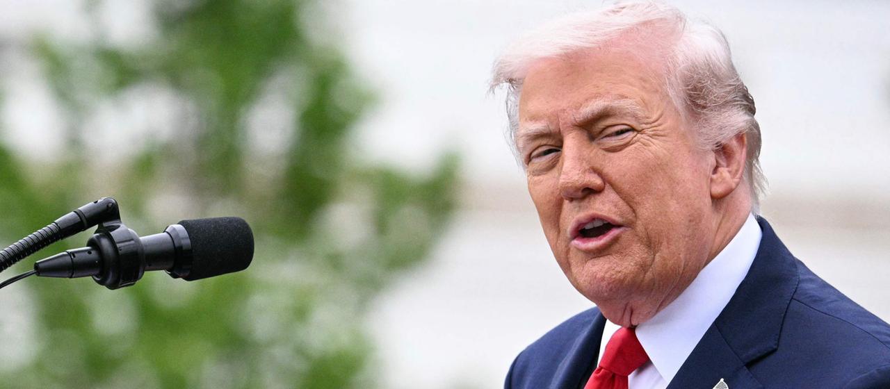 Donald Trump speaks on a stage