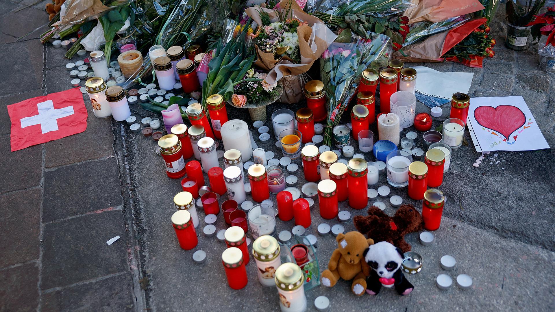 Kerzen und Blumen liegen in der Nähe der Unglücksstelle. | REUTERS