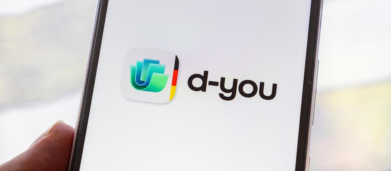 Nahaufnahme von einem Smartphone mit dem Logo der d-you-App.