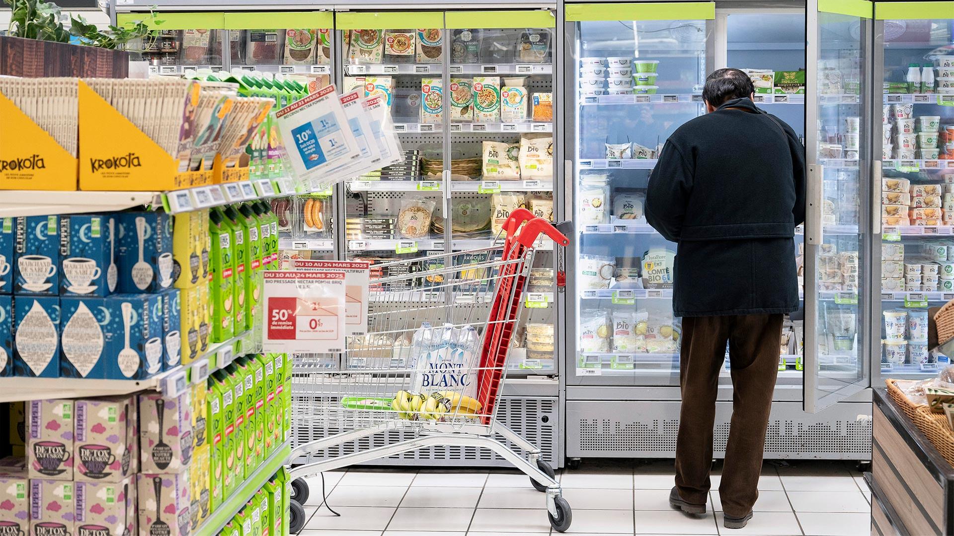 Eine Kunde steht in einem Supermarkt in Frankreich vor einem Kühlregal. | picture alliance / Hans Lucas