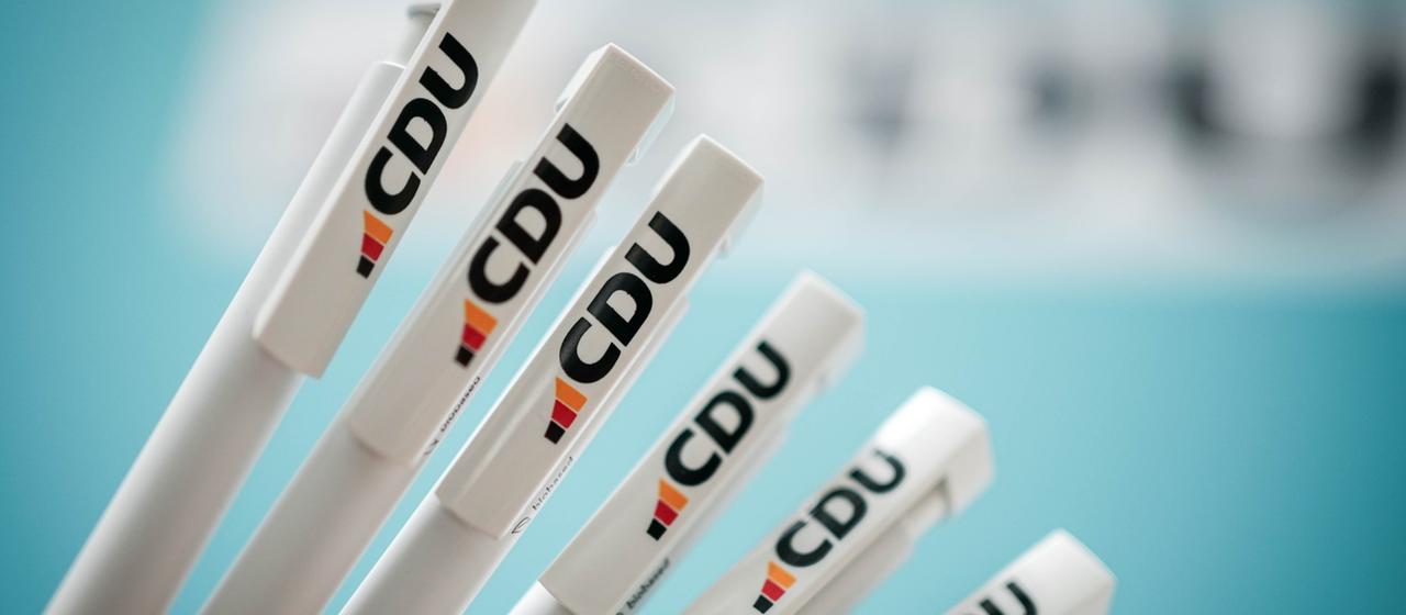 Sechs weiße Kugelschreiber mit dem neuen Logo der CDU