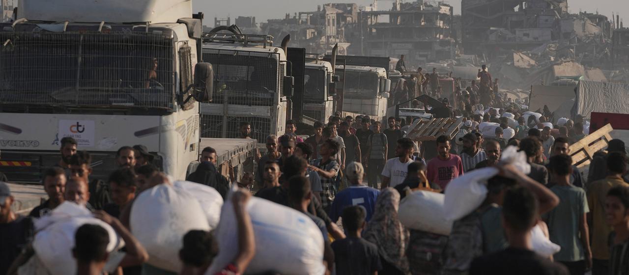 Palästinenser tragen Mehlsäcke, die von einem humanitären Hilfskonvoi abgeladen wurden, der Gaza-Stadt aus dem nördlichen Gazastreifen erreicht hat | AP Palästinenser tragen Mehlsäcke, die von einem humanitären Hilfskonvoi abgeladen wurden, der Gaza-Stadt aus dem nördlichen Gazastreifen erreicht hat