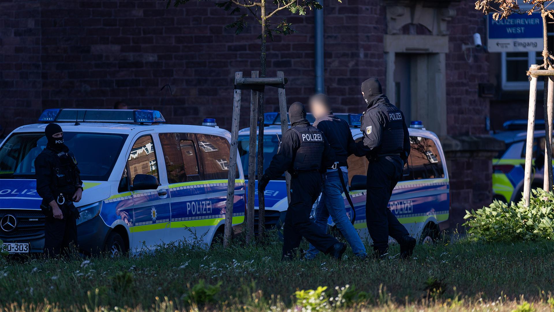 Ein Mann wird von einem Polizisten zu einem Fahrzeug der Bundespolizei geführt | dpa