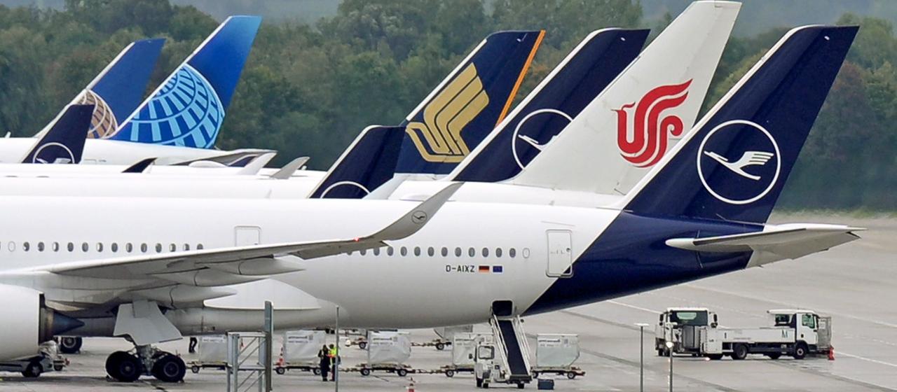 Flugezuge verschiedener Fluggesellschaften stehen an einem Flughafen.