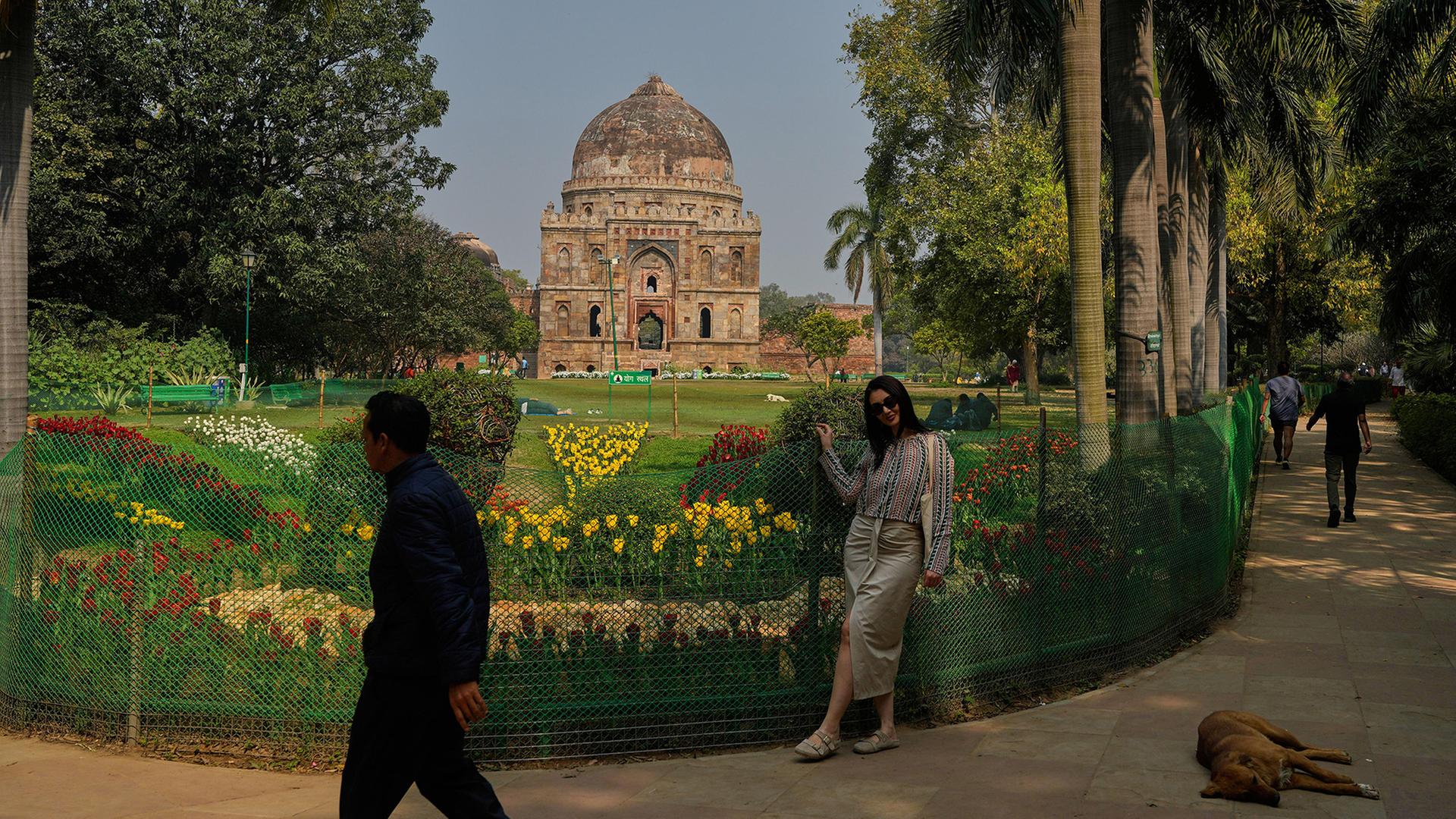 Eine Touristin posiert wÃ¤hrend des Tulpenfestivals, das den Wechsel der Jahreszeiten im indischen Neu-Delhi feiert, zwischen Tulpenreihen im Lodhi Garden. | AP
