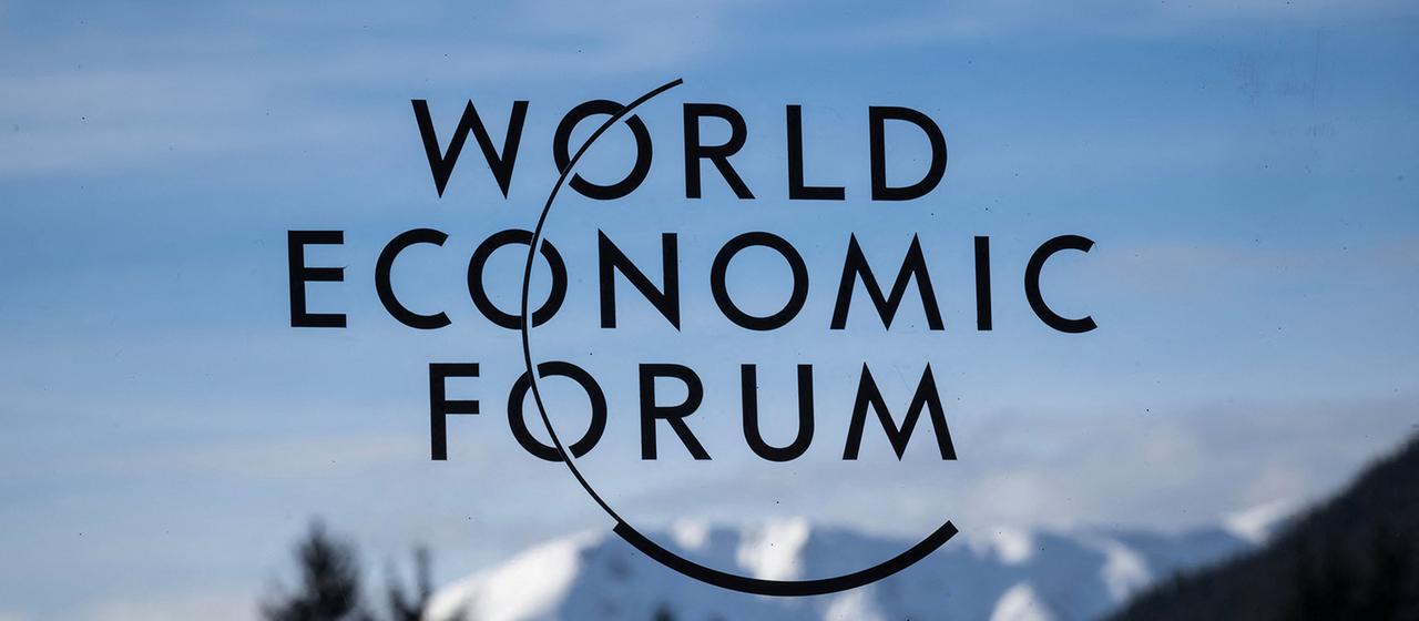 Auf einer Glasscheibe ist das Logo des "WORLD ECONOMIC FORUM" vor einem Bergpanorama zu sehen. (Archivbild: 20.1.2025)