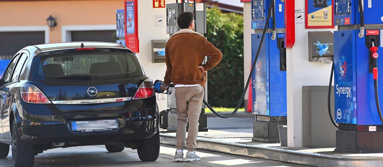 Ein Mann betankt sein Auto an einer Tankstelle.