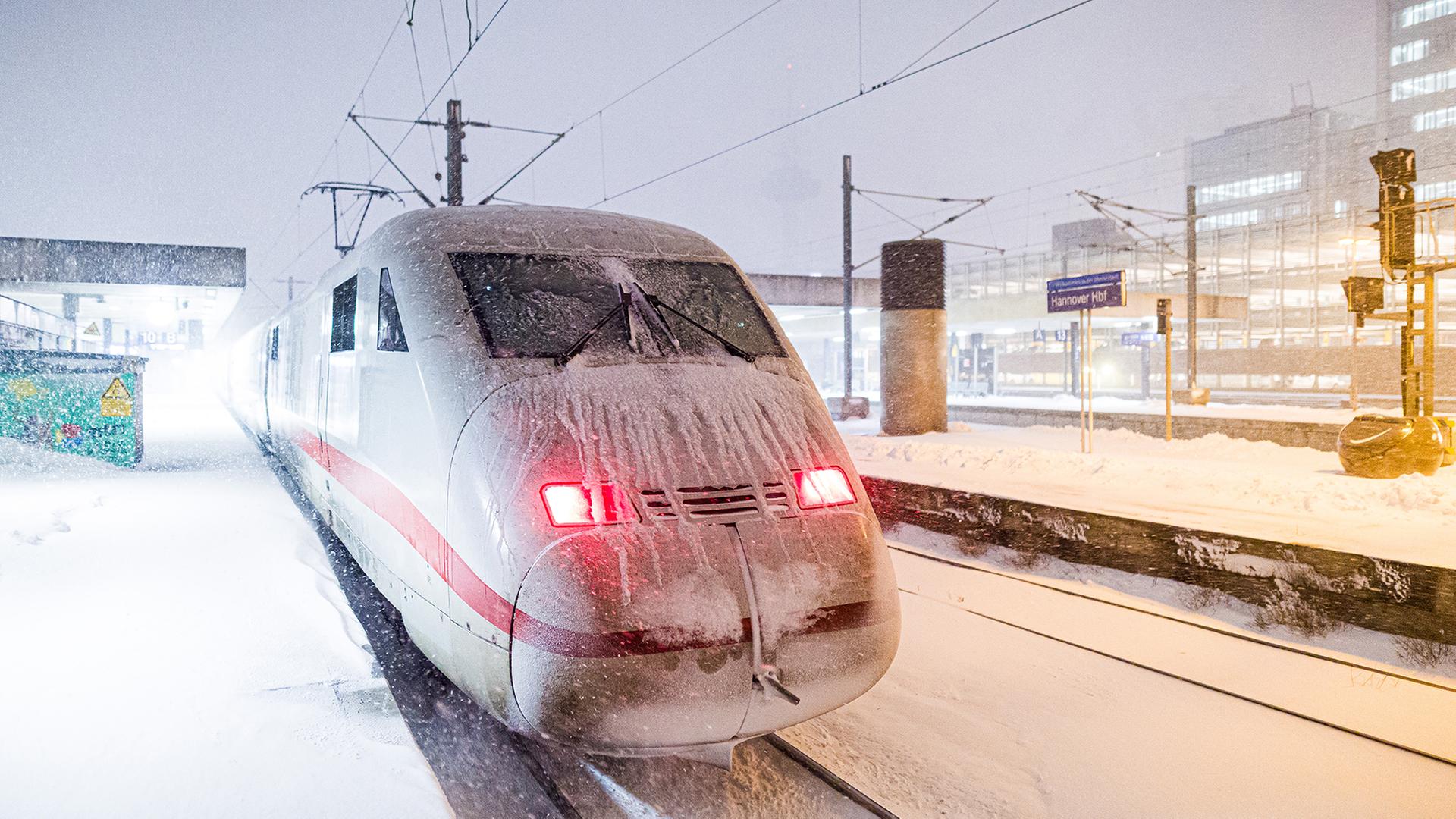 Ein ICE steht am frühen Morgen an einem verschneiten Gleis im Hauptbahnhof von Hannover. | dpa