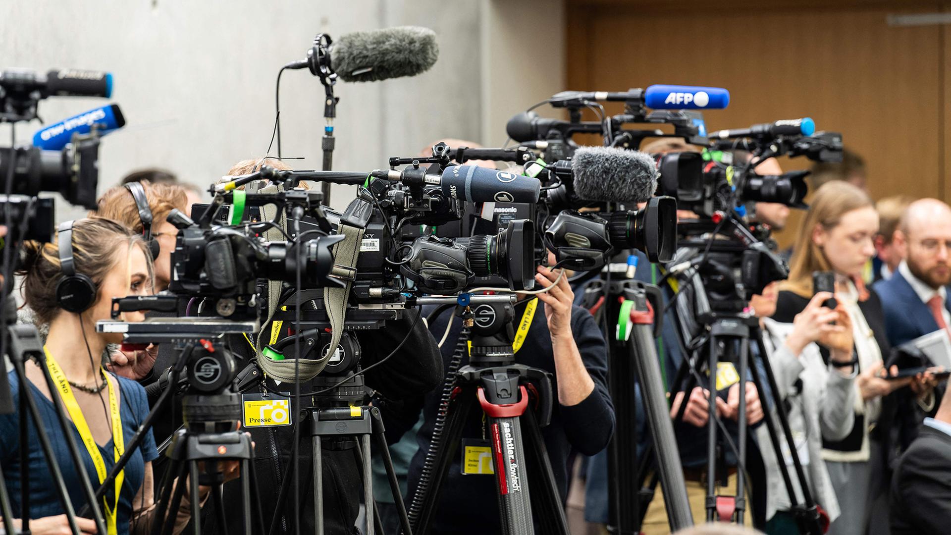 Kameras, Mikrofone und Medienvertreter stehen dicht gedrängt nebeneinander. | AFP