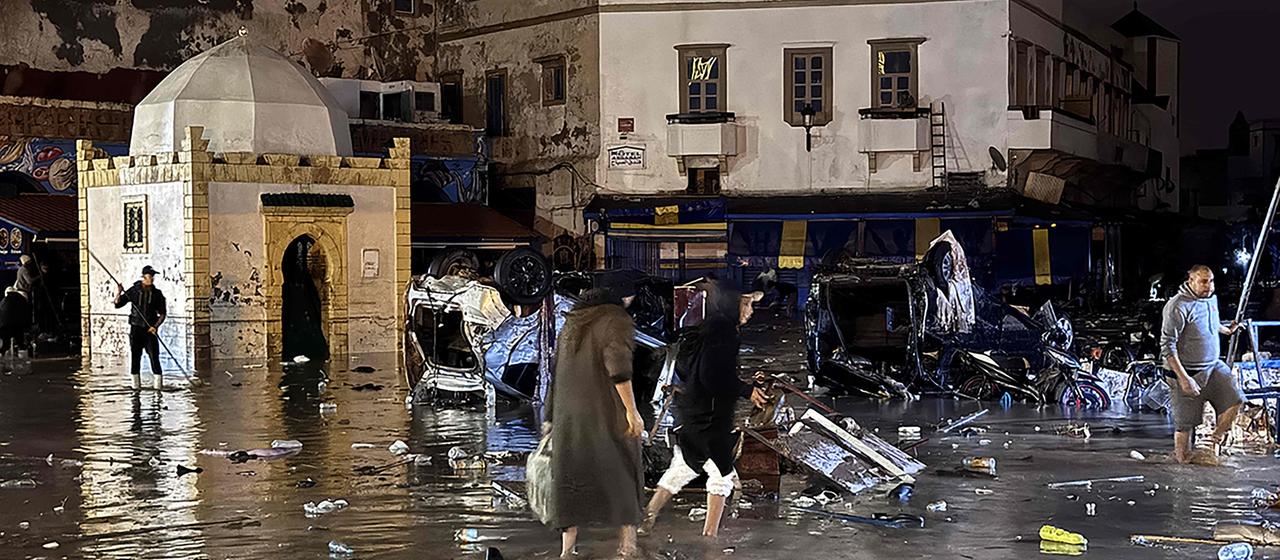 Menschen waten nach einer Sturzflut durch das Wasser im marokkanischen Safi