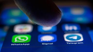 Nahaufnahme mit Finger über den Messenger-Apps WhatsApp, Signal und Telegram auf einem Smartphone