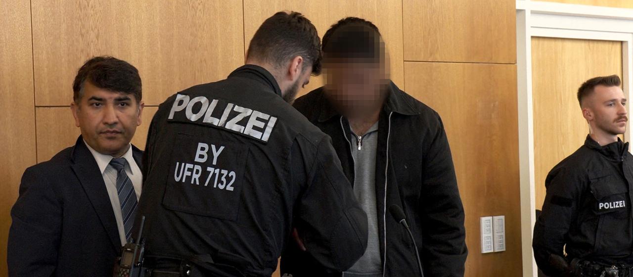 Der Angeklagte Enamullah O. bei seiner Ankunft im Gerichtssaal in Aschaffenburg.
