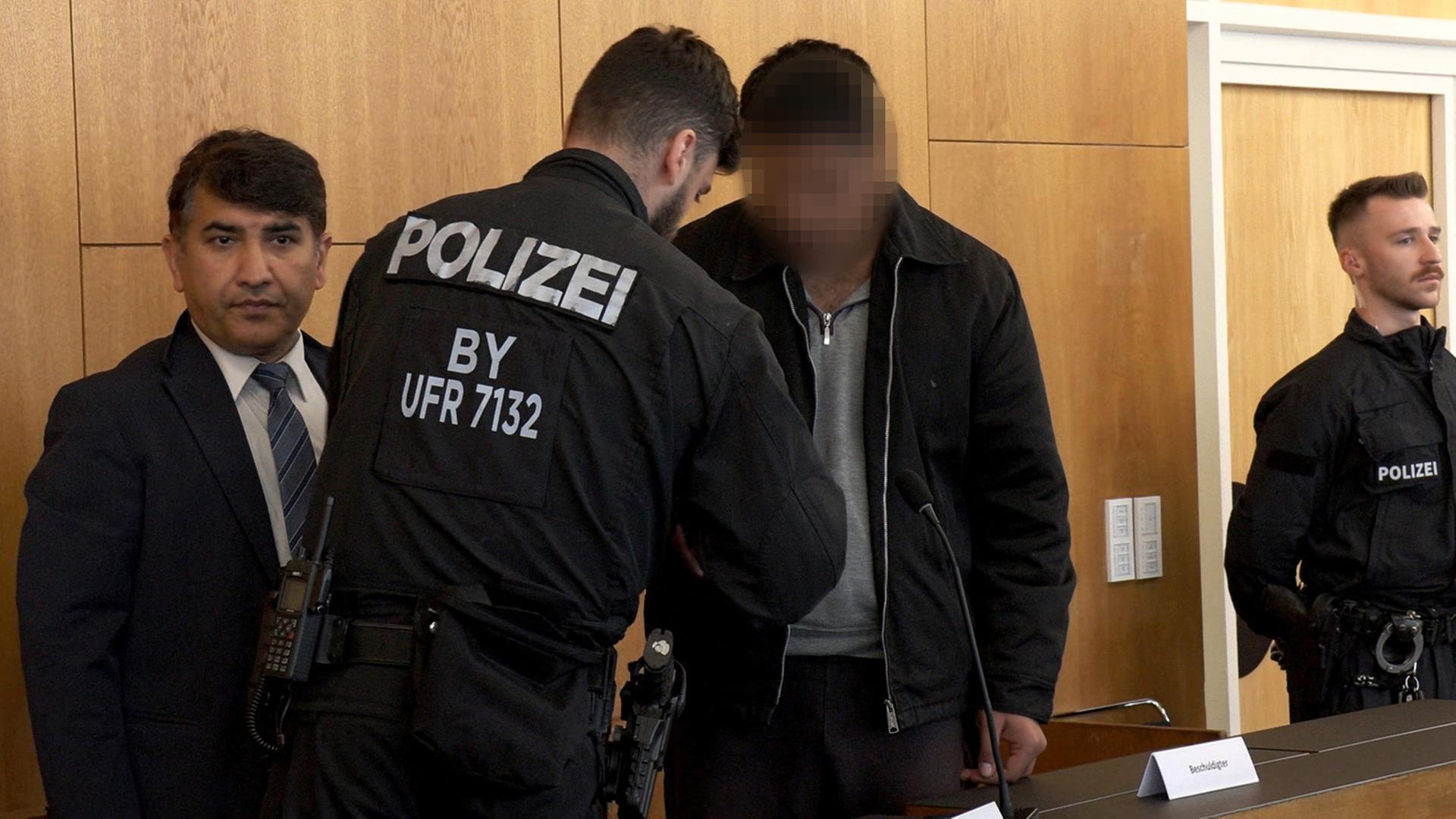 Der Angeklagte Enamullah O. bei seiner Ankunft im Gerichtssaal in Aschaffenburg. | AFP