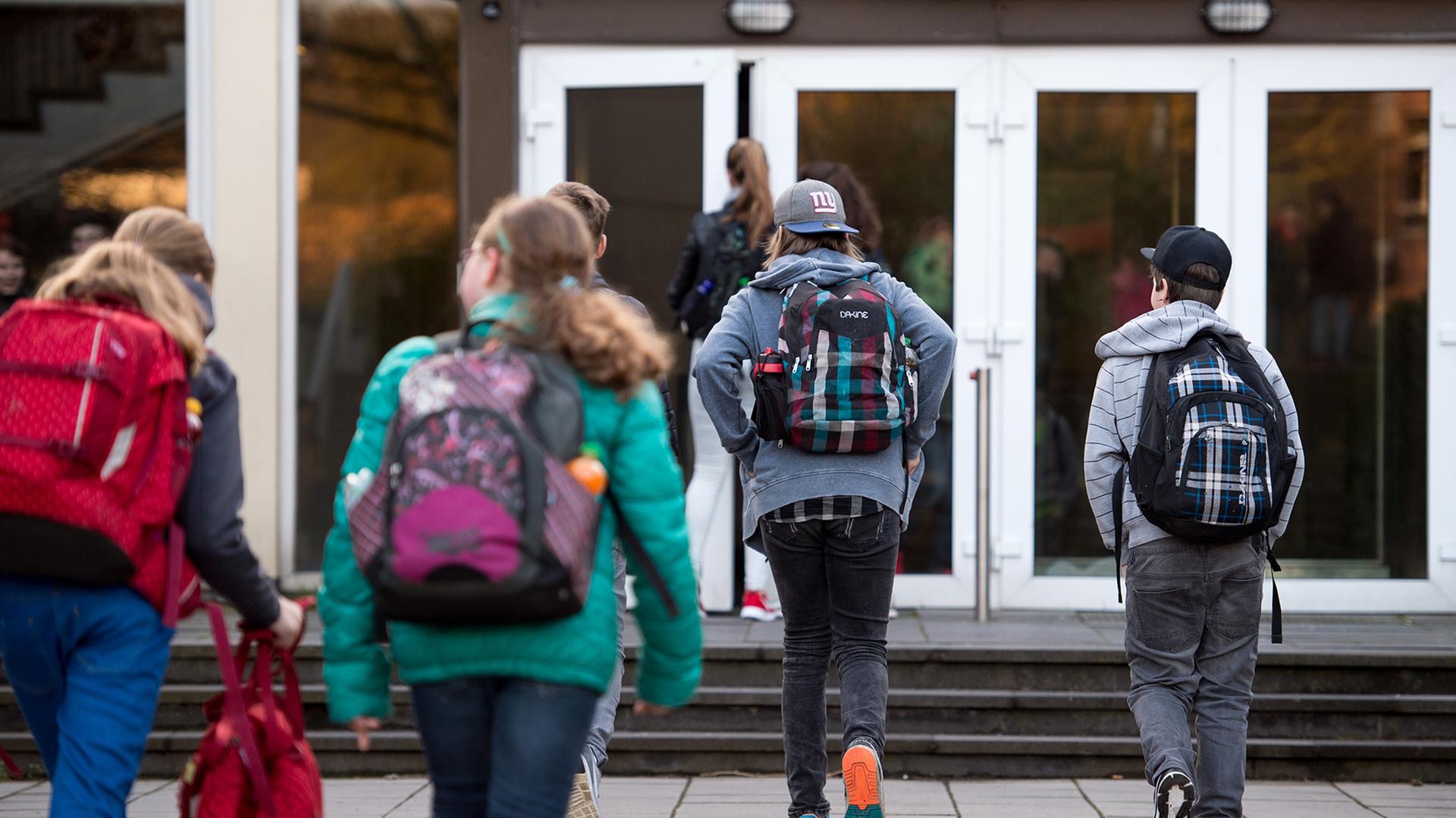 Schülerinnen und Schüler gehen zum Eingang eines Gymnasiums. | picture alliance / dpa