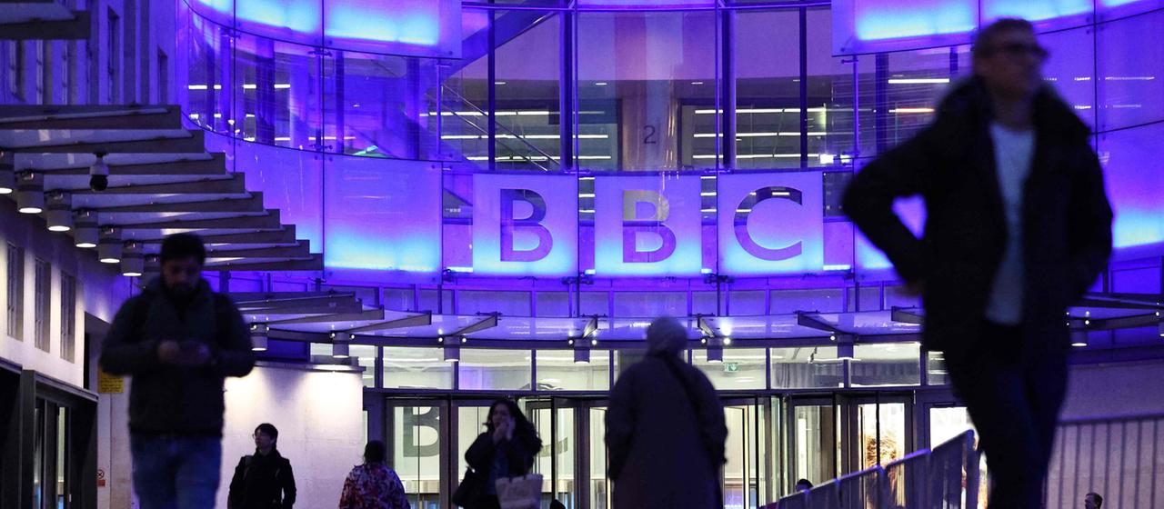Menschen gehen vom Eingang zum BBC-Gebäude in London.