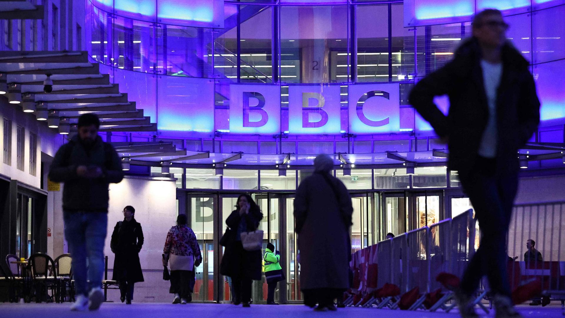 Menschen gehen von dem Eingang des BBC-Gebäudes in London. | AFP