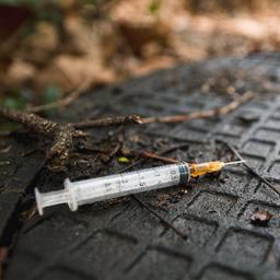 Eine benutzte Spritze liegt auf dem Boden.