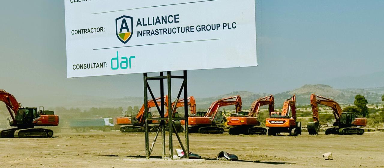 Bagger stehen hinter einem großen Schild