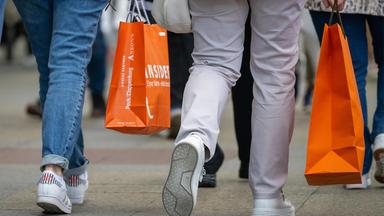 Menschen tragen Einkaufstüten.