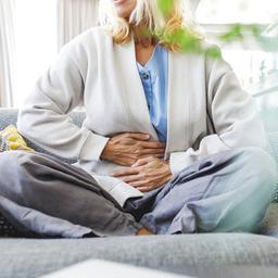 Eine Frau legt die Hände auf ihren Bauch.