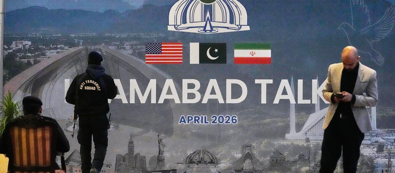 Sicherheitskräfte befinden sich vor einer Plakatwand mit der Aufschrift "Islamabad Talks".