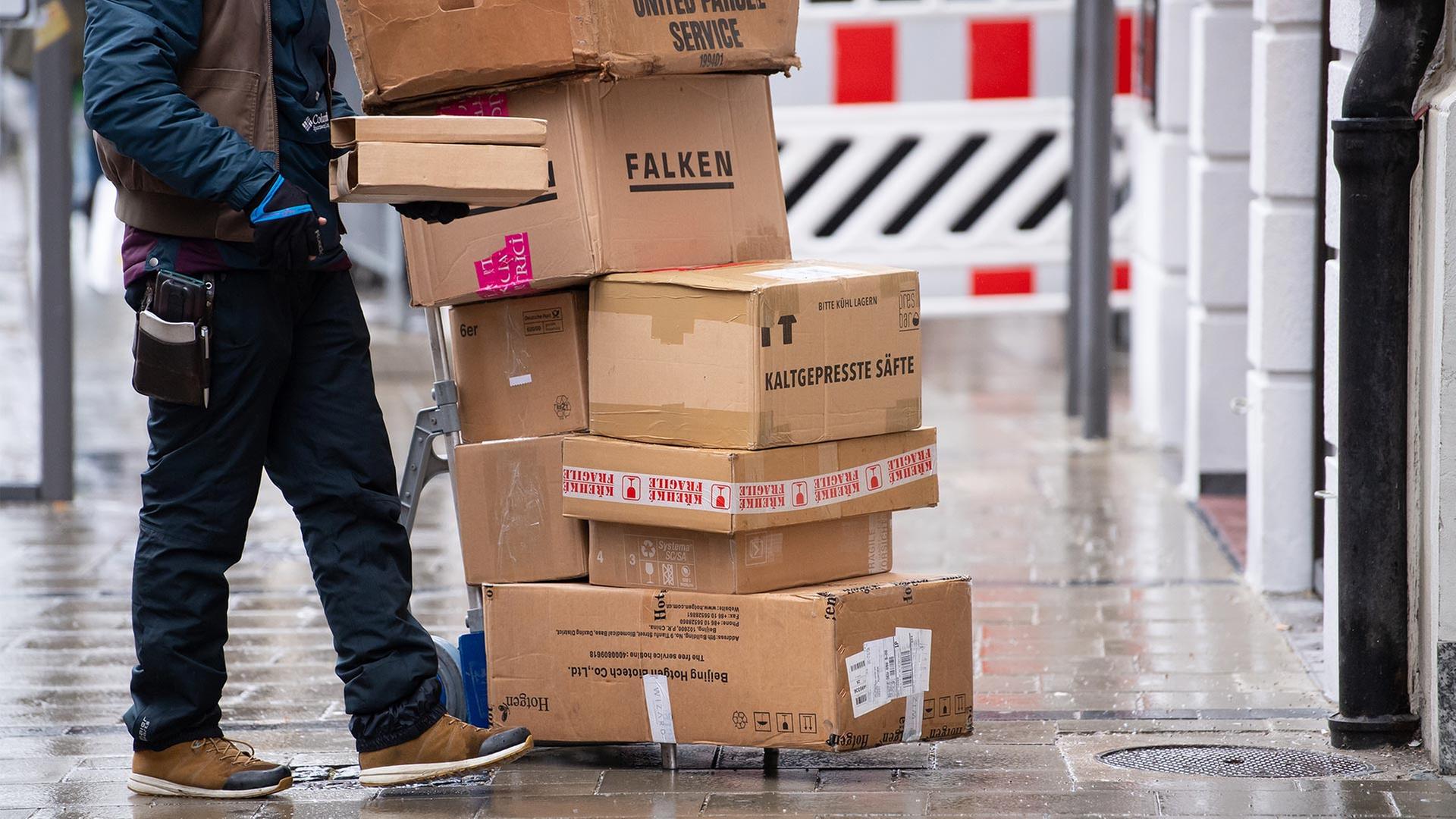 Paketbote bei der Auslieferung. | picture alliance/dpa