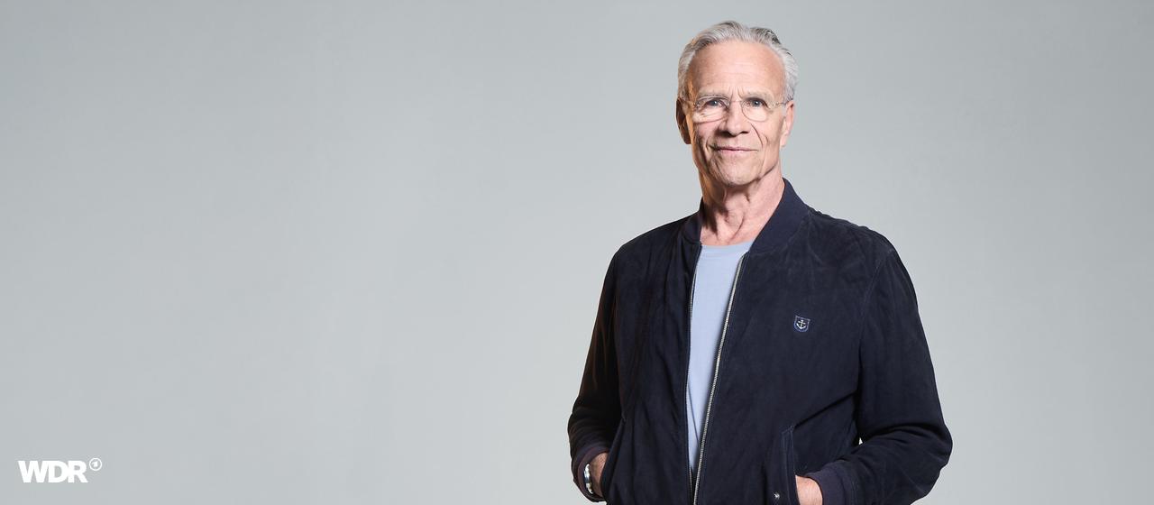 Schauspieler Klaus Johannes Behrendt vor einer weißen Wand