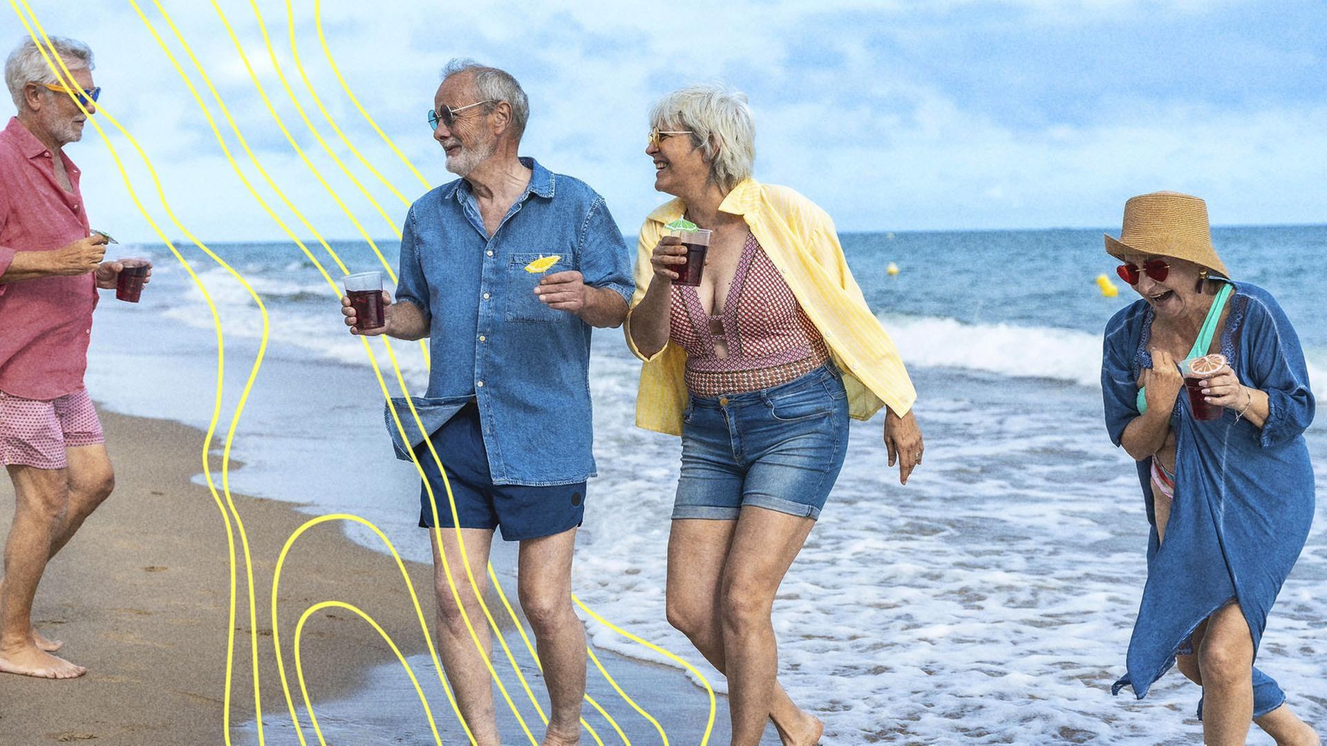 Gruppe glÃ¼cklicher Ã¤lterer Freunde, die lachen und barfuÃ am Sandstrand spazieren gehen. | picture alliance / imageBROKER | Unai Huizi
