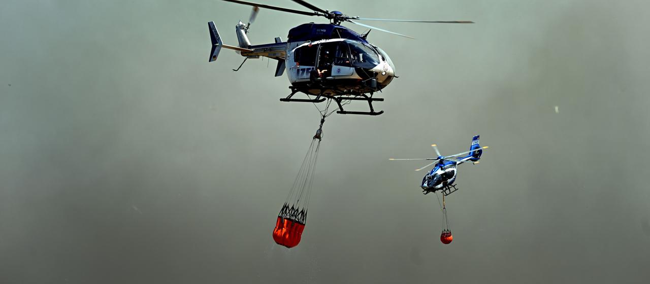 Helikopter der Polizei mit Löschwasser-Außenlastbehältern
