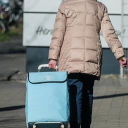 Eine Seniorin mit Einkaufstrolley