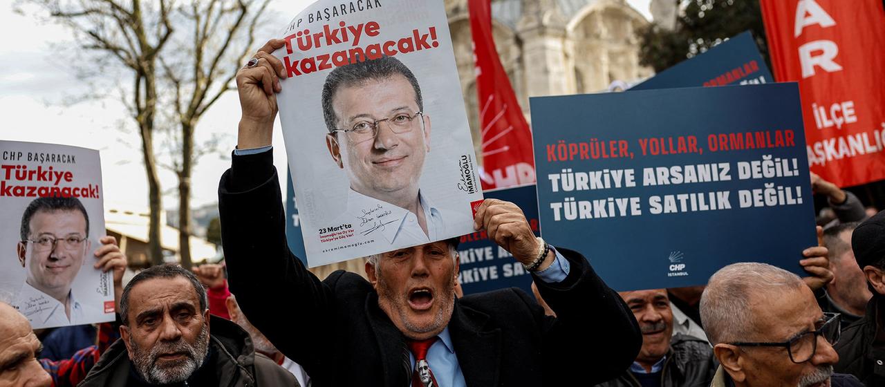 Menschen halten auf einer Demonstration im türkischen Istanbul Plakate von Ekrem Imamoglu hoch.