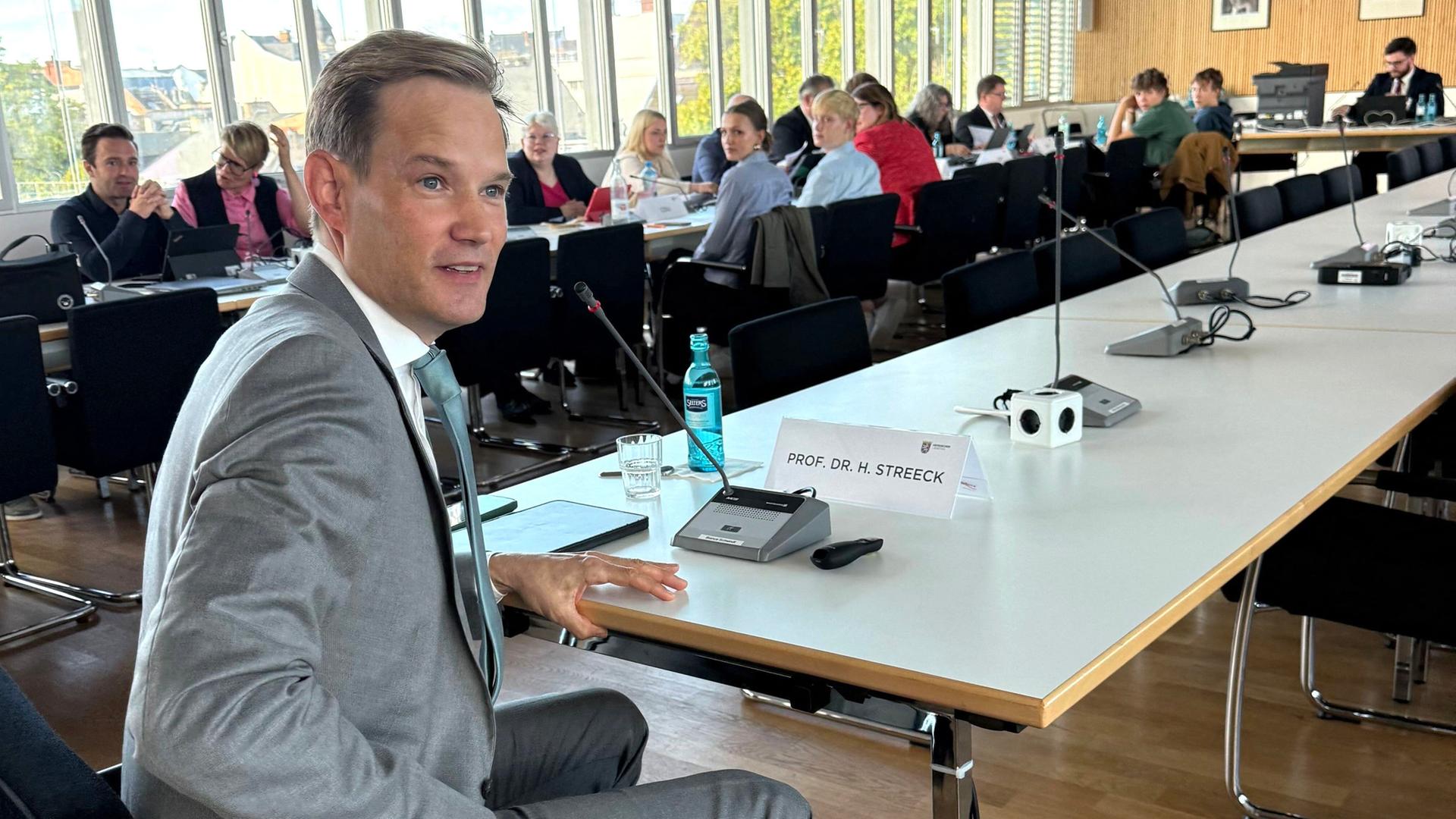 Hendrik Streeck sitzt im Corona-U-Ausschuss an einem Tisch.  | picture alliance/dpa | Andrea Löbbecke