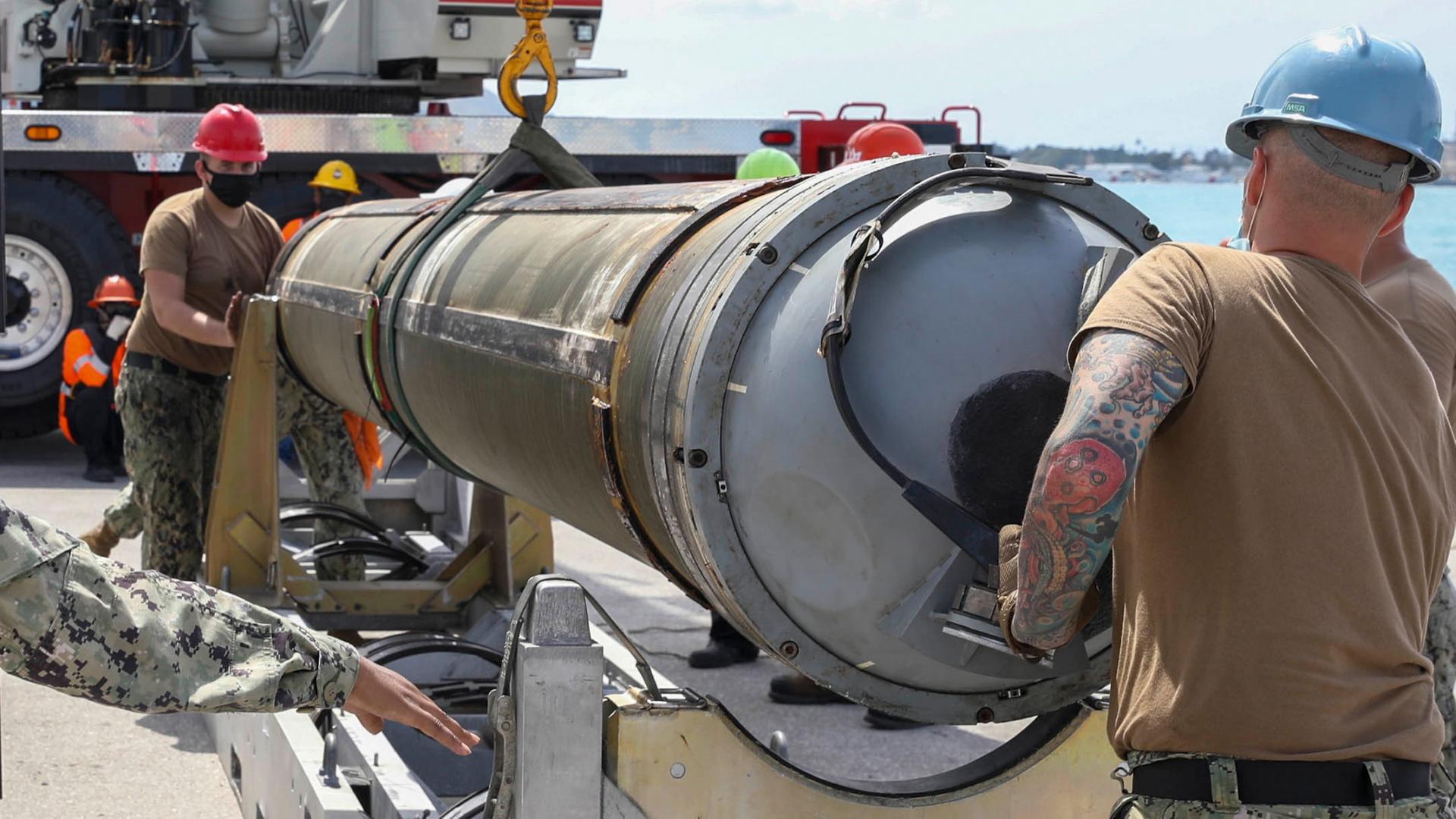 Auf diesem von der Marine der USA zur Verfügung gestellten Bild entladen Matrosen des U-Boot-Tenders USS Emory S. Land (AS 39), Abteilung Waffenhandhabung, eine Tomahawk-Rakete vom Schnellangriffs-U-Boot USS Asheville (SSN 758) der Los Angeles-Klasse.  | dpa