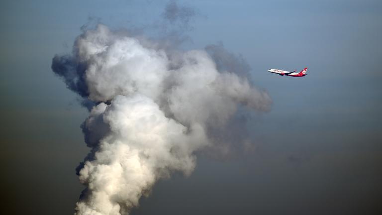 Ein Flugzeug der Airline "Air Berlin" fliegt am 02.11.2015 kurz nach dem Start in Berlin-Tegel an einer riesigen Wasserdampfwolke des Heizkraftwerkes Reuter in Siemensstadt vorbei.