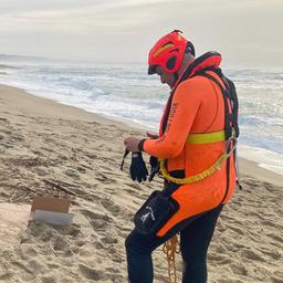Ein Retter steht neben einem Fahrzeug vor der Küste Kalabriens, an einem Strand in der Nähe von Cutro, Süditalien.