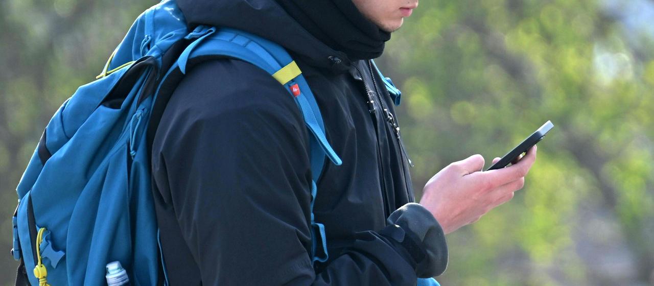 Ein Jugendlicher mit einem Smartphone in Wien, Österreich.