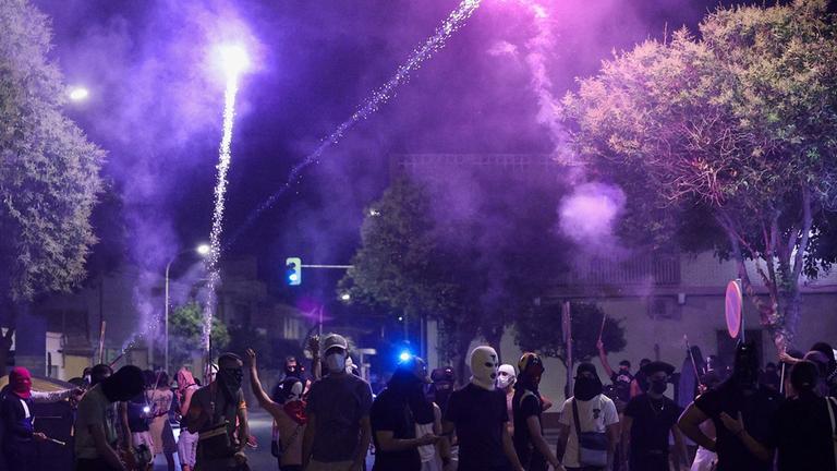 Bewaffnette und maskierte Männer stehen in Torre Pacheco, Spanien auf einer Straße