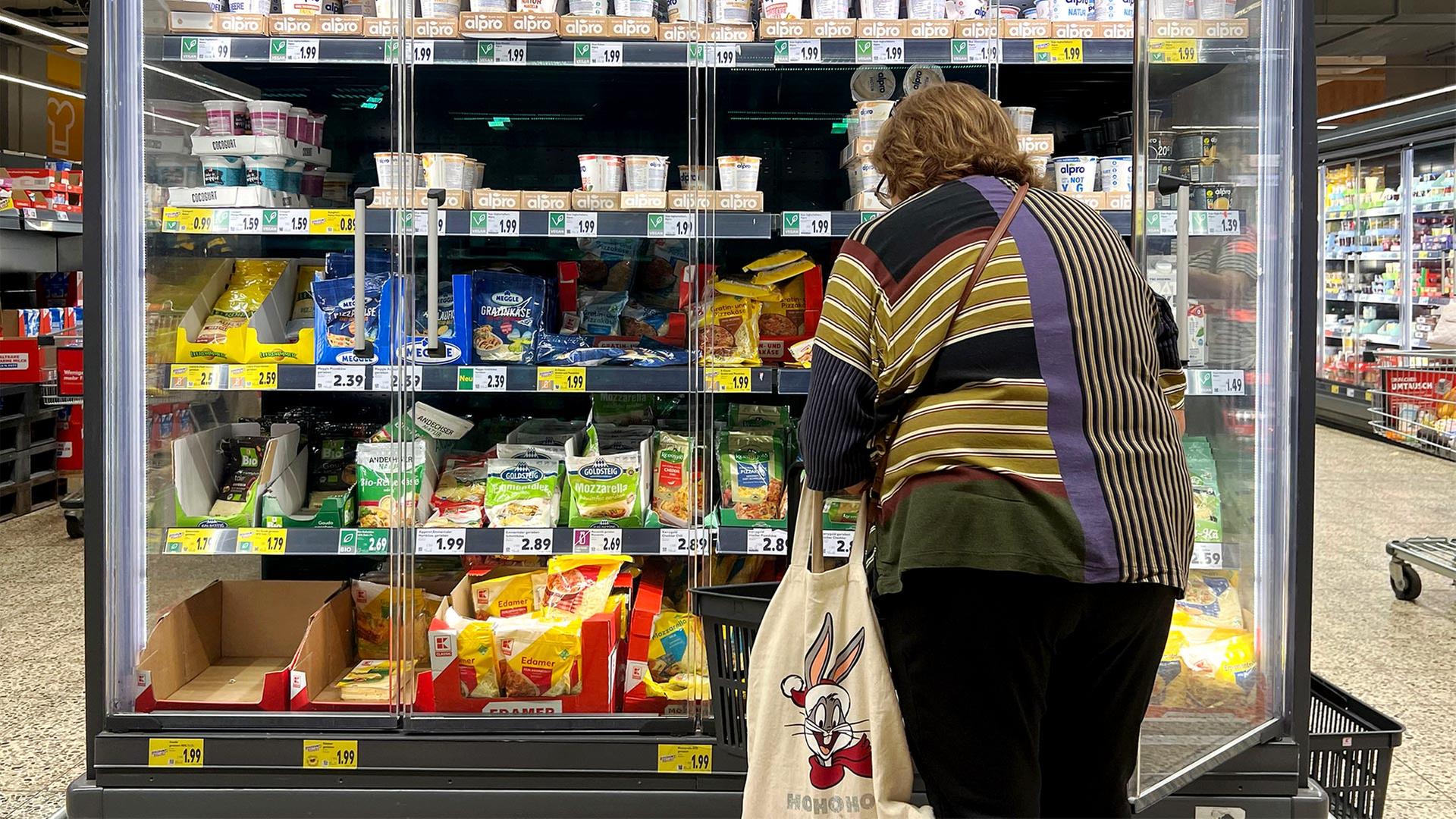 Eine Kundin vor einem Kühlregal in einem Supermarkt. | picture alliance / SvenSimon