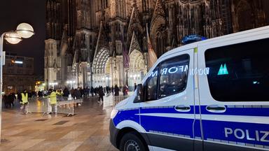 Ein Einsatzfahrzeug der Polizei steht vor dem Dom.