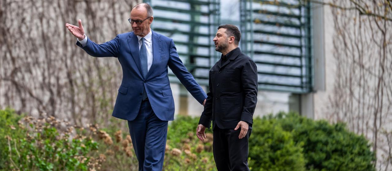 Friedrich Merz und Wolodymyr Selenskyj laufen gemeinsam einen Weg entlang