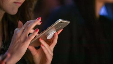Eine Frau tippt auf ihrem Smarthphone