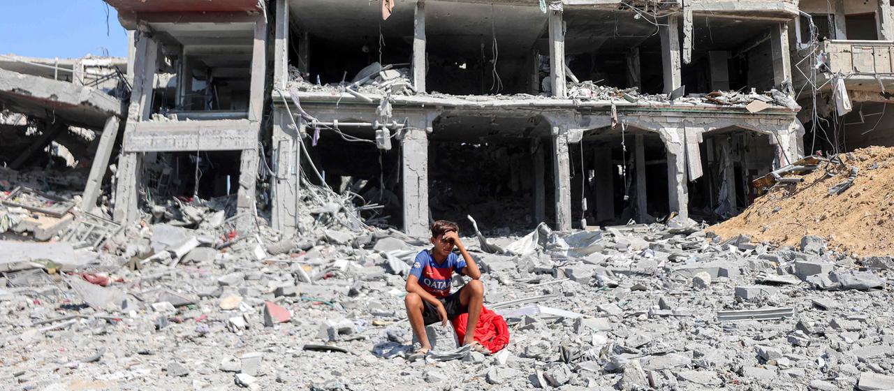 Ein Junge sitzt vor einem zerstörten Haus in Chan Junis | AFP Ein Junge sitzt vor einem zerstörten Haus in Chan Junis