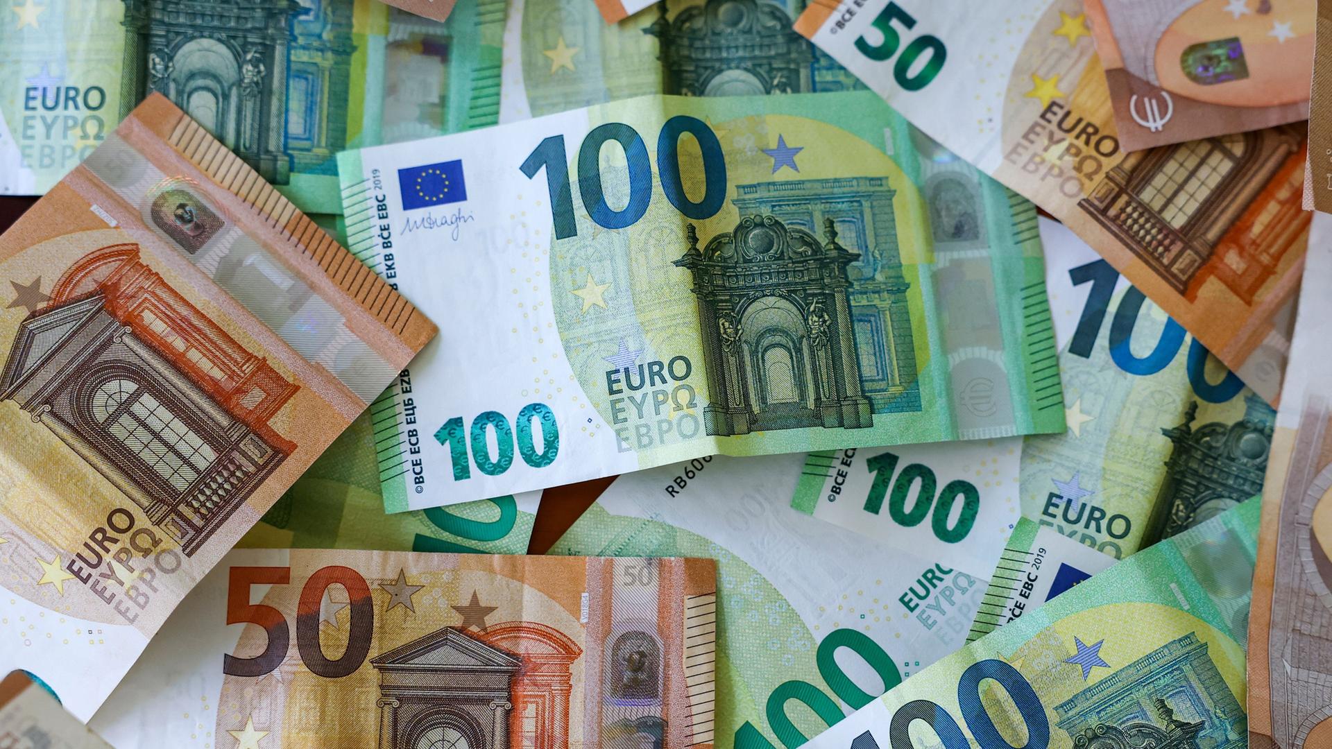 Mehrere Hunderter und Fünfziger Euro Geldscheine liegen auf einem Tisch. | Jan Woitas/dpa