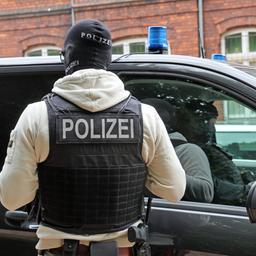 Ein maskierter Polizist steht in Neubukow vor einem Einsatzfahrzeug. (Archivbild: 21.05.2025)