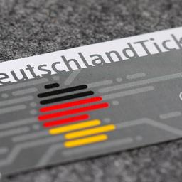 Ein Deutschlandticket liegt auf einer grauen Fläche