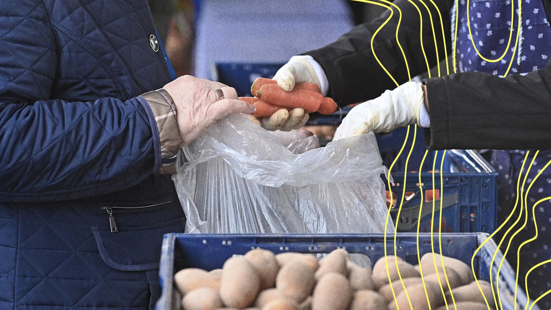An der Tafel werden Karotten ausgegeben. | picture alliance / SvenSimon, Frank Hoermann/SVEN SIMON