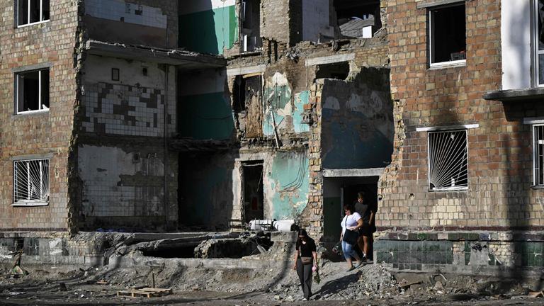 Anwohner verlassen ein zerstörtes Wohngebäude in Kiew, Ukraine.