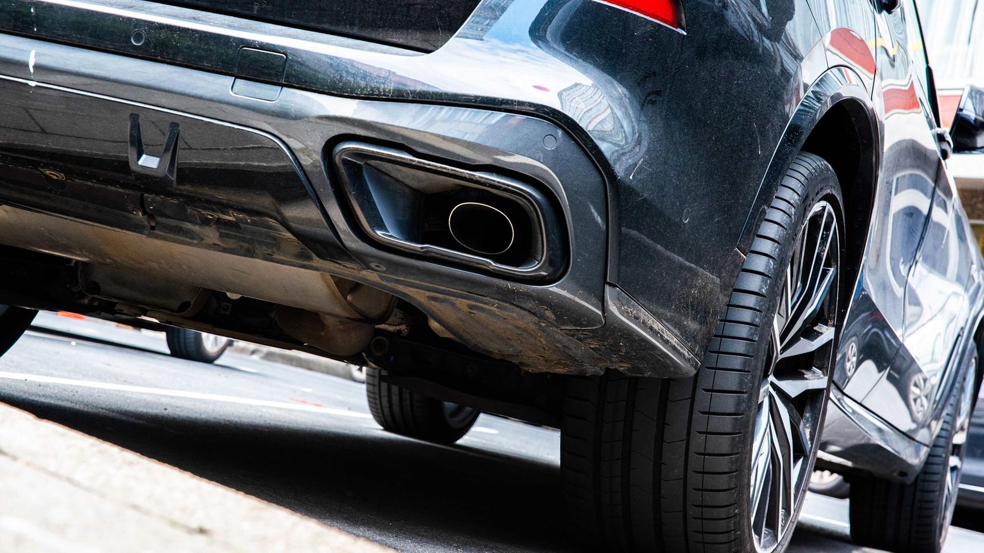 Der Auspuff eines dunklen SUVs. | dpa